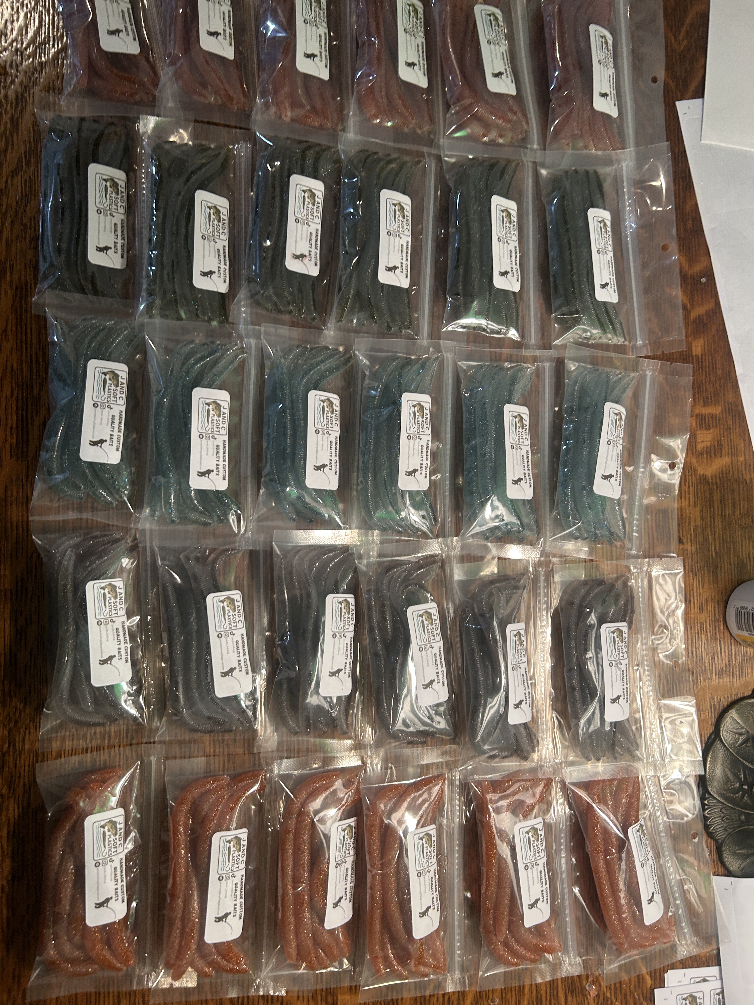 Six metal molds with a fish design lined up neatly on a bench, showcasing a range of fish shapes; the most prominent fish-...